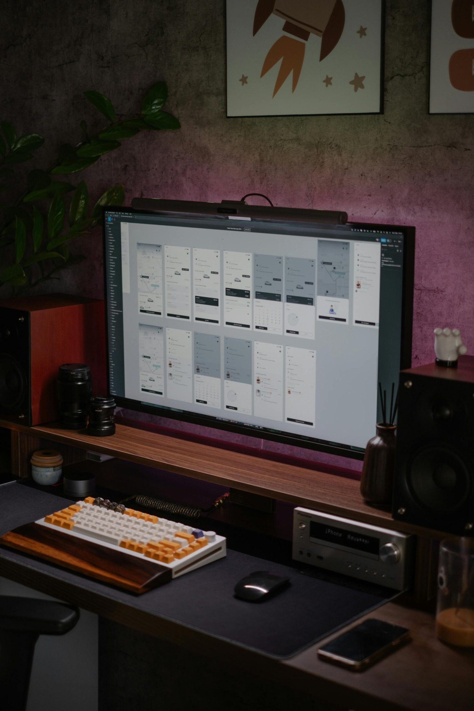 Stylish home office desk with a large monitor displaying UI designs.